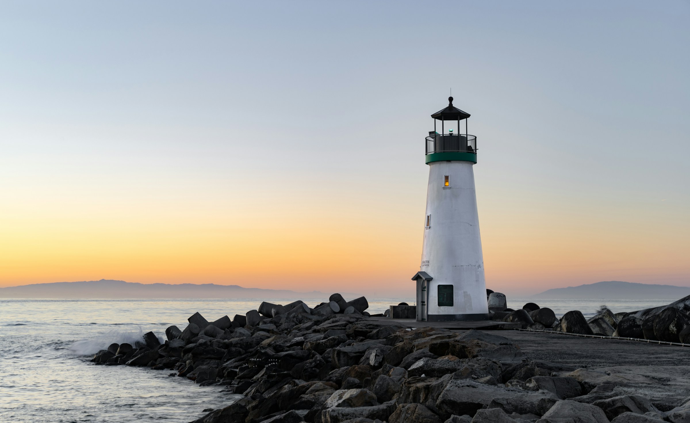 A lighthouse on a breakwater at dawn